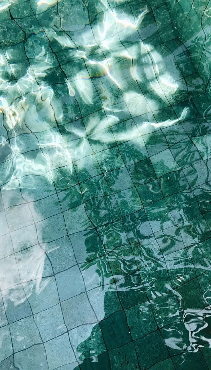 Sunlight rippling across a tiled pool floor